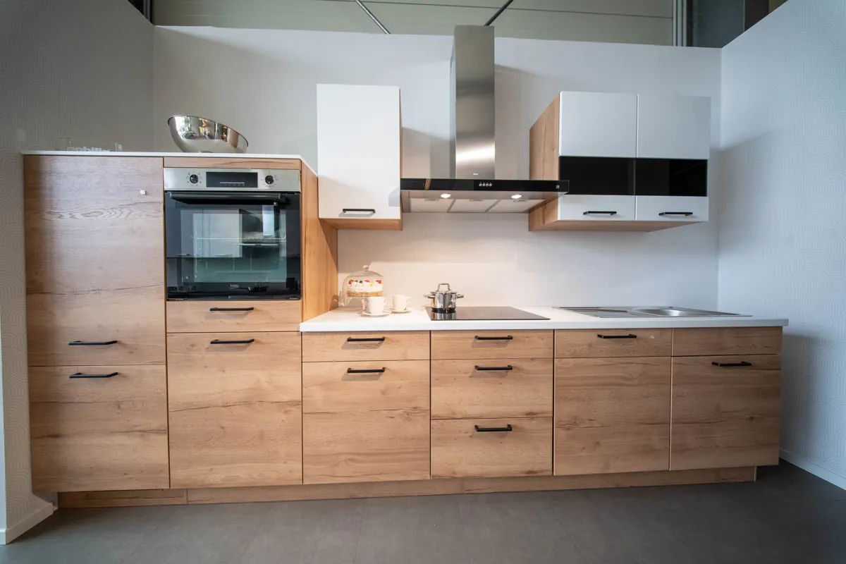 Küchenzeile mit Holzfronten, weißen Oberschränken und hochgebautem Backofen