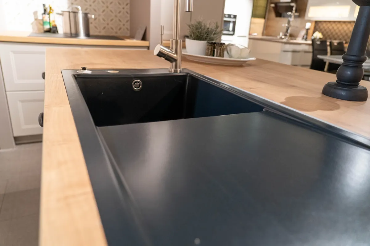 Dunkles Spülbecken in einer Arbeitsfläche in Holzoptik