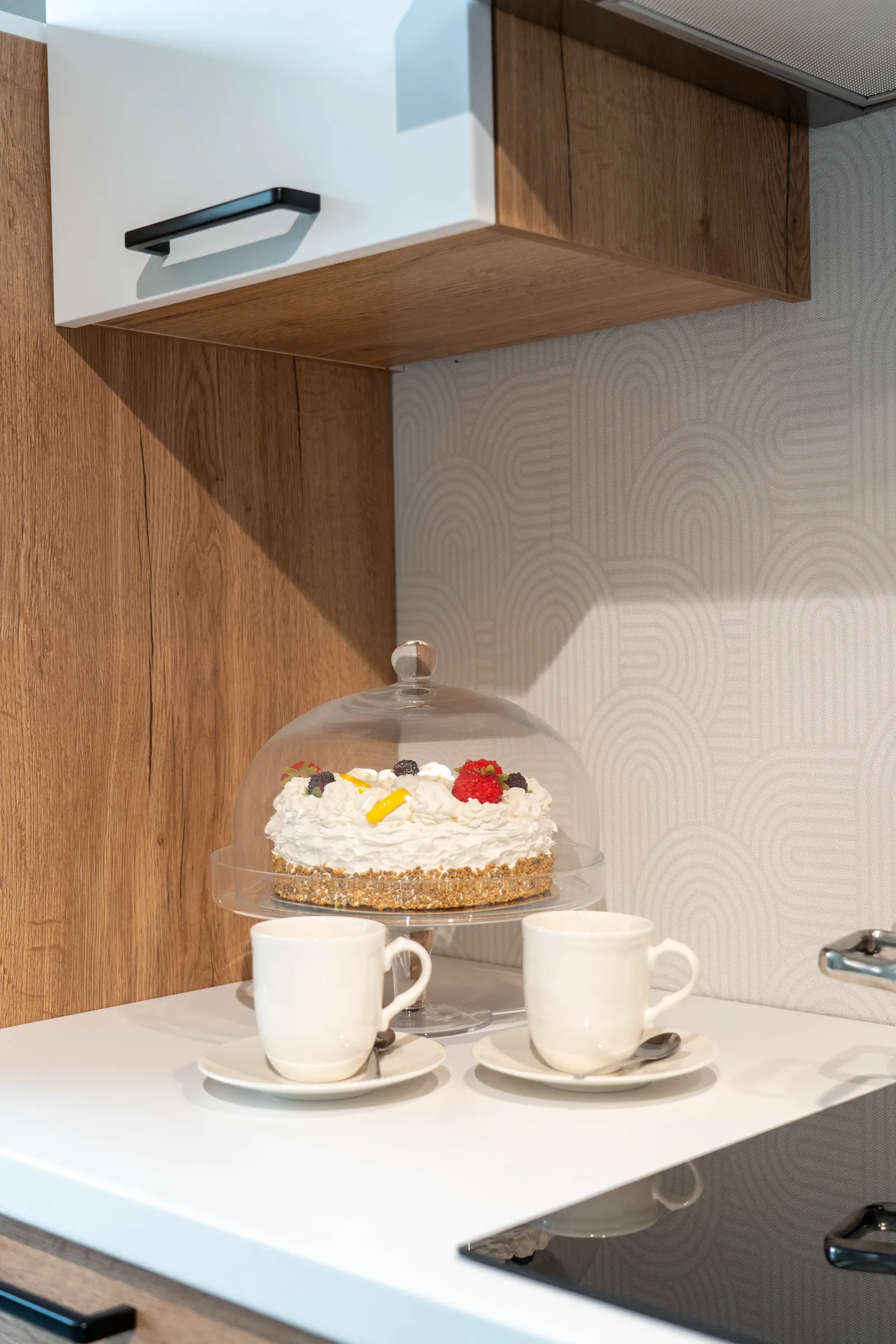 Zwei Kaffeetassen und Torte auf heller Arbeitsplatte in der Ausstellung