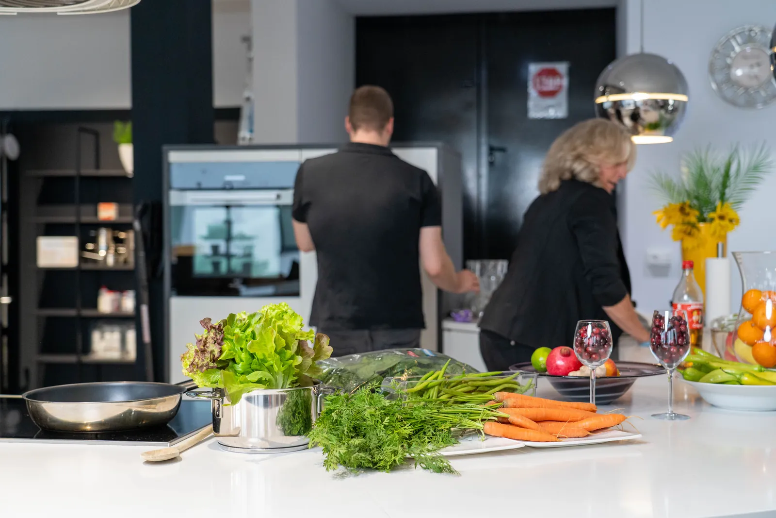 Gemeinsames Kochen in der Ausstellungsküche mit frischem Gemüse, Kräutern und Obst